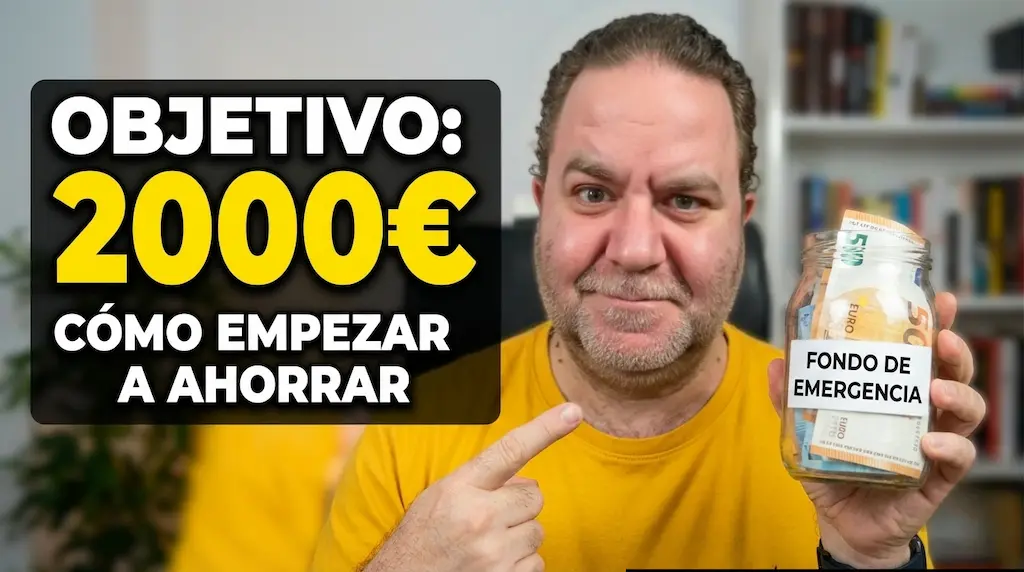 Primer plano de Javier Fuentes, mirando fijamente a cámara con expresión decidida y confiada, sujetando un tarro de cristal con dinero y una etiqueta que pone Fondo de Emergencia. Aparece junto a un texto grande y llamativo que destaca la cifra '2.000€', haciendo referencia al objetivo de ahorro para la cuenta de imprevistos mencionado.