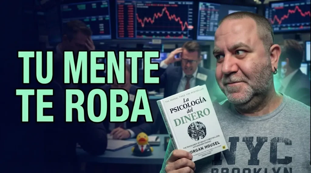 Javier Fuentes con expresión escéptica sostiene el libro 'La Psicología del Dinero' en español. Texto grande en verde neón 'TU MENTE TE ROBA'. Fondo oscuro con gráficos de bolsa en rojo y un pato de goma con traje desenfocado.