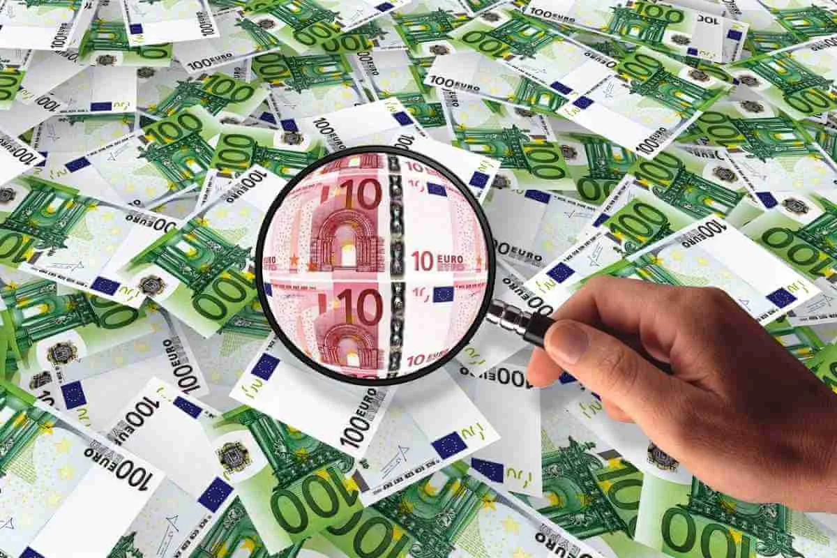 Balanza con una bolsa de dinero (ahorro) y una cadena (deuda), con flechas de inflación afectándolas de forma diferente